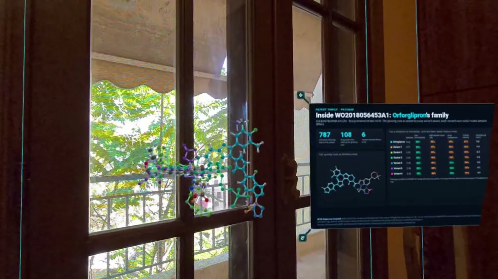 A patent family panel beside a 3D molecule in front of a window